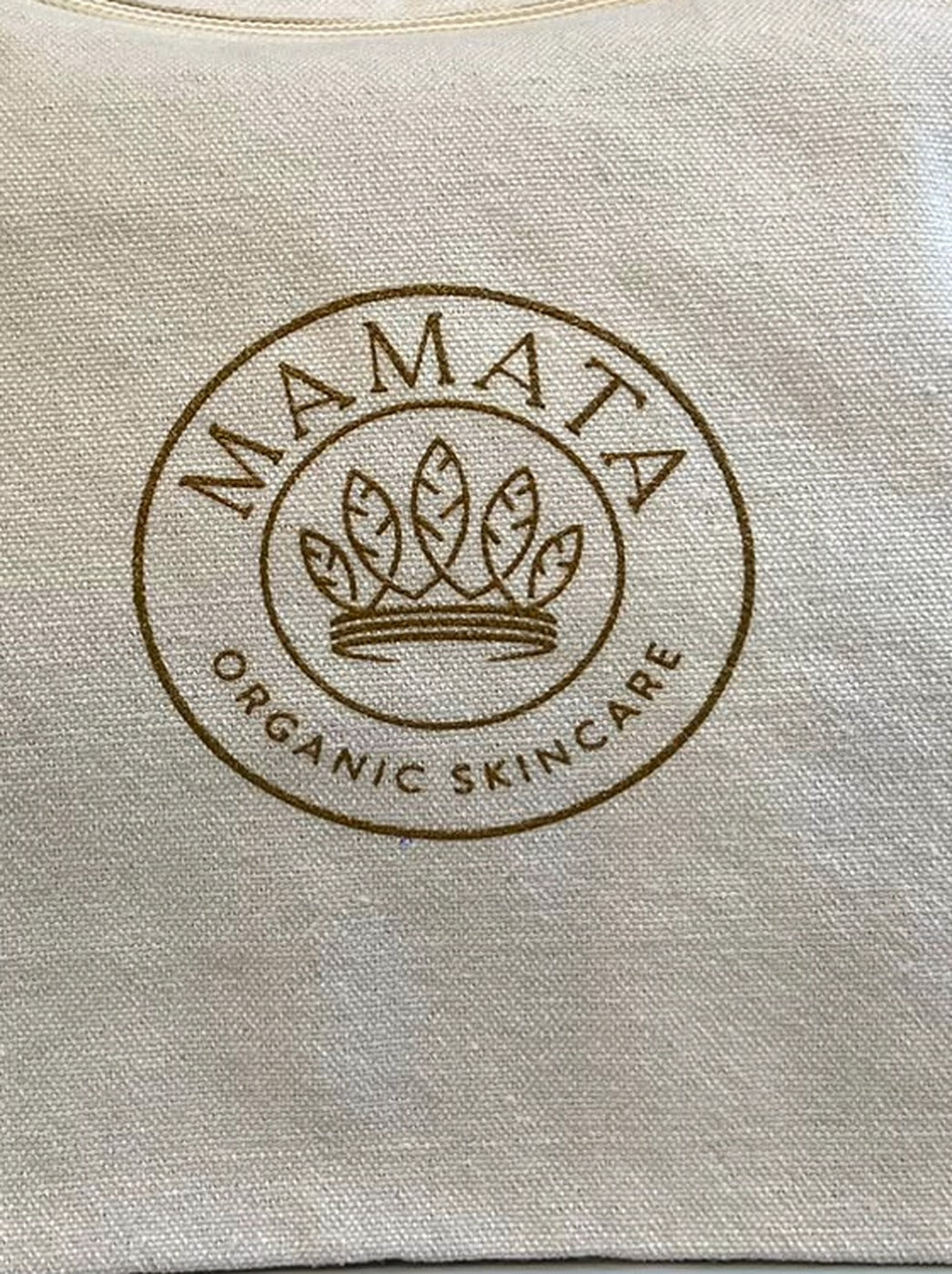Dettaglio del logo Mamata Organic Skincare stampato in oro sul tessuto in cotone riciclato